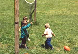 Three little boys play ball